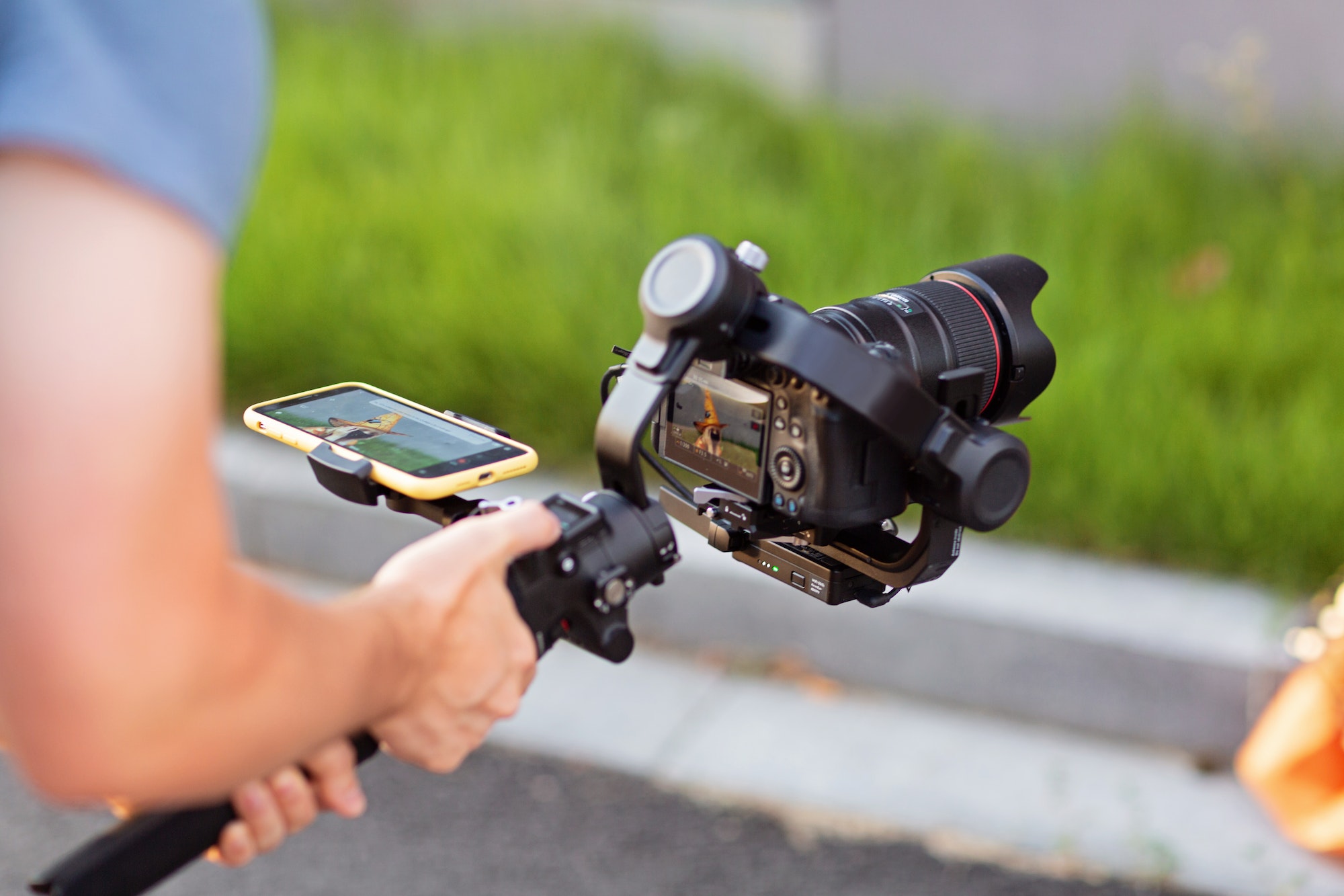 Operator using modern technology: stabilizer for camera and app on mobile phone for video streaming